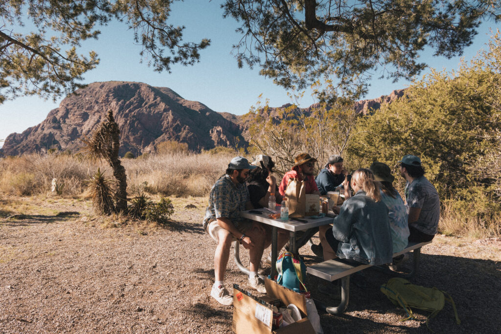 Group of friends eating at a picnic table