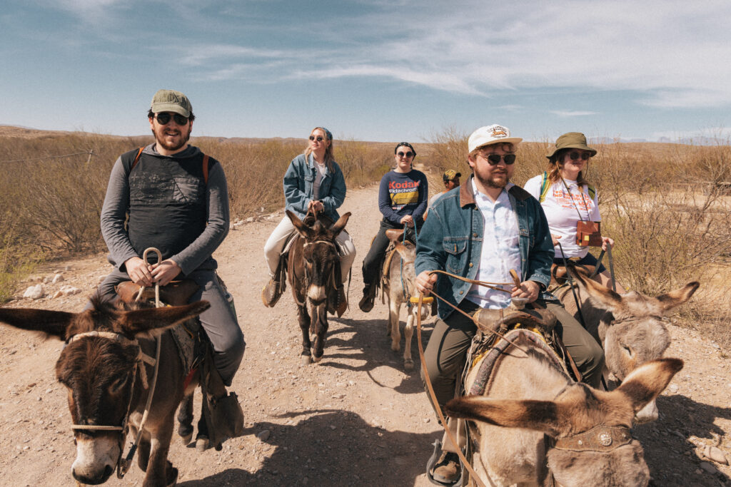 Group of friends riding donkeys outside of Big Bend National Park